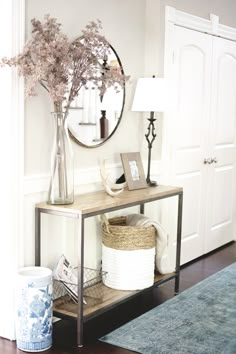 a vase with flowers on a shelf next to a mirror and lamp in a room