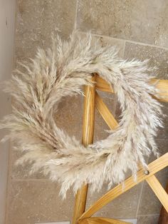 a wreath made out of wood and some white fur on the floor next to a chair