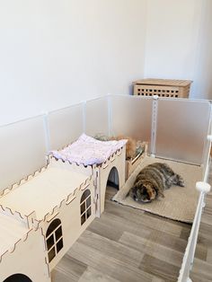 a cat laying on the floor next to a dog house