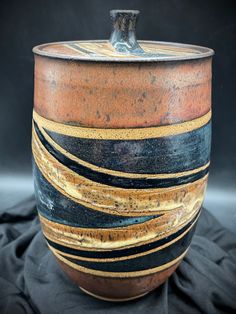 a brown and black pot sitting on top of a table