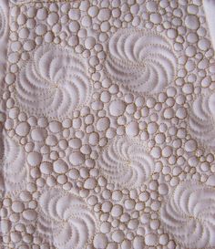 an intricate quilt with white circles on it