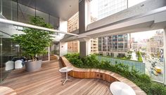 a wooden bench sitting on top of a hard wood floor next to a tall building