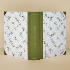 an open book with floral designs on the front and back cover, sitting on a table