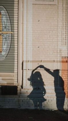 the shadow of a person standing in front of a building with a cross on it