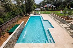 an aerial view of a swimming pool surrounded by trees