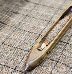 an old wooden pen laying on top of a piece of cloth next to a pair of scissors