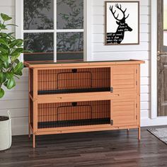 a large wooden cabinet with two cages on top of it in front of a door