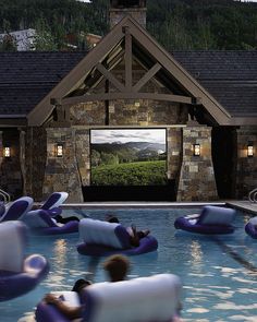 an outdoor movie is set up next to a pool with inflatable lounge chairs