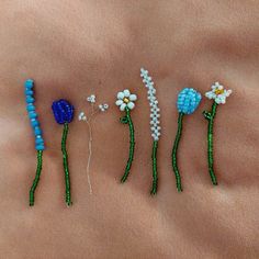 four beaded flowers are on the side of a woman's stomach with beads attached to them