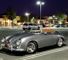 an old car parked in a parking lot at night