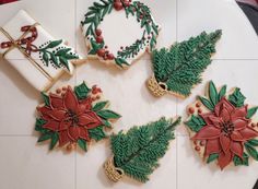 decorated cookies on a plate with holly and poinsettis