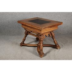 an old wooden table with a black top