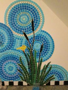 a vase filled with flowers sitting on top of a tiled counter next to a wall