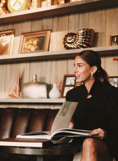 a woman sitting at a table reading a book