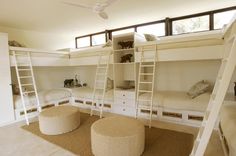 a room with bunk beds and stools in it