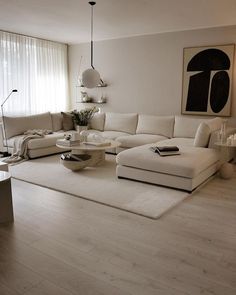 a living room with white furniture and large windows