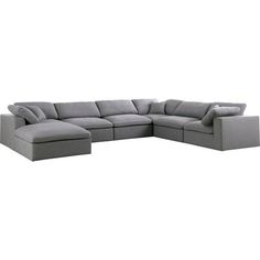 a gray sectional couch with pillows on it's back and side facing the camera