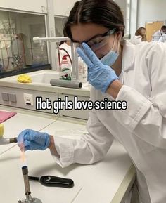 a woman in white lab coat and blue gloves holding a pipe with liquid on it