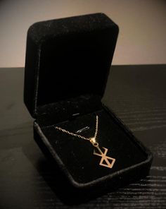 an open box with a necklace in it