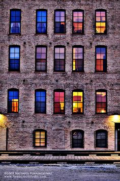 an old brick building with many windows lit up at night