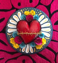 a heart shaped box with flowers around it