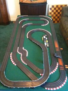 a toy race track set up on a green carpeted floor in a living room