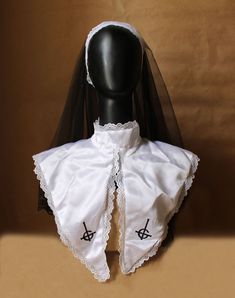 a mannequin wearing a white dress with black trimmings and a veil