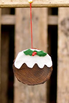 an ornament hanging from a wooden pole with a red string attached to it