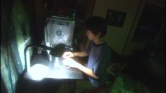 a young boy sitting at a table with a typewriter in front of him