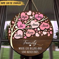 a family tree sign hanging from the side of a window with pink hearts on it