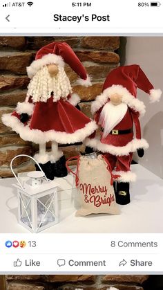 two santa clause figurines sitting on top of a table next to a bag