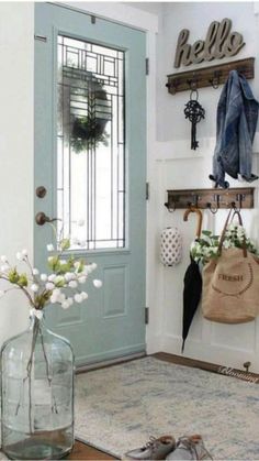 a vase with flowers on the floor next to a blue door