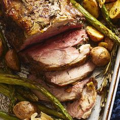 roast beef with potatoes and asparagus on a platter