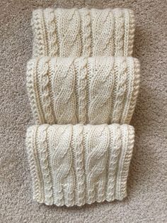 two white knitted items laying on the floor