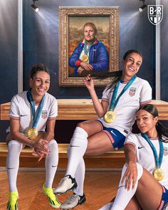 two women sitting on a bench with medals around their necks and one holding a tennis racquet