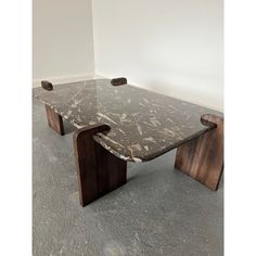 a marble top coffee table with wooden legs