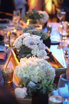 the table is set with white flowers and candles