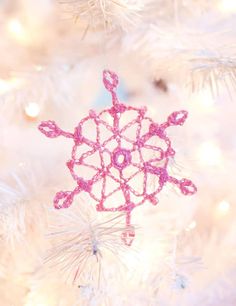 a snowflake ornament hanging from a christmas tree