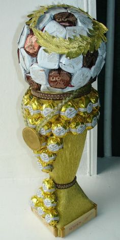 a gold and white vase filled with lots of candy