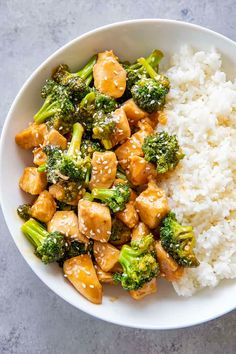 a bowl filled with rice, broccoli and tofu on top of it