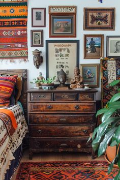 a bed room with a neatly made bed and lots of framed pictures on the wall