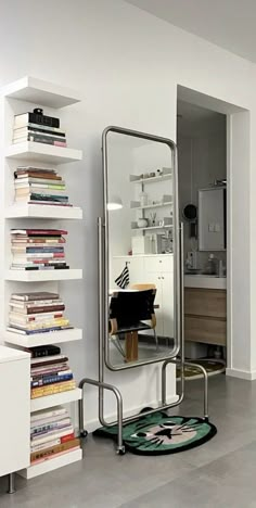 a mirror sitting on top of a white wall next to a book shelf