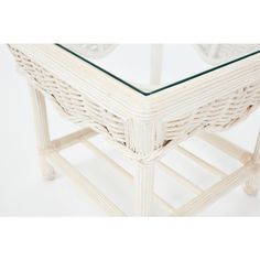 a white wicker table with glass top