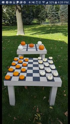 an outdoor chess board game set up in the grass with cupcakes on it