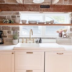 a white kitchen sink sitting under a window next to a counter top with dishes on it