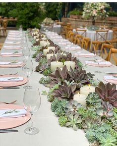 a long table is set with place settings and candles for dinner guests to sit at