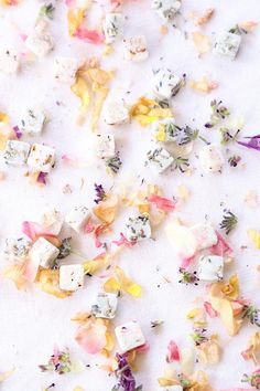 colorful flowers scattered on top of a white surface