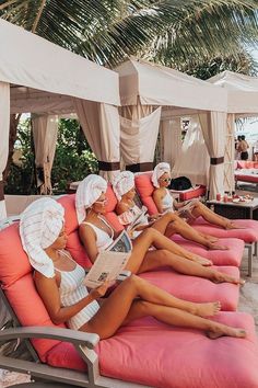 several women lounging on lounge chairs at the beach