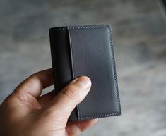 This minimalist bifold wallet or Business card case in a compact profile. It is fully lined (including the pockets) with french goat skin and made from gorgeous Novonappa Calf skin from Tanneries Haas DETAILS: - Made from Novonappa Calf Skin leather from Tanneries Haas in Chocolate - Fully lined with tonal Sully French Goat Skin leather from Alran SAS, or Chèvre - 2 fully lined credit card pockets that can hold 3 - 4 cards, or plenty of business cards -Third pocket on the exterior is not lined to reduce bulk, but will hold an additional 2 to 3 cards - Hand stitched , with a saddle stitch, using your choice of Linen thread - The edges will be hand painted and finished to match the exterior leather unless otherwise requested  DIMENSIONS:  4.2" x 2.5" when closed Minimalist Trifold Wallet For Business, Minimalist Business Trifold Wallet, Wallet Minimalist, Slim Leather Wallet, Business Card Case, Clip Wallet, Minimalist Wallet, Money Clip Wallet, Bifold Wallet