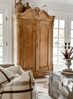 a large wooden armoire in a living room